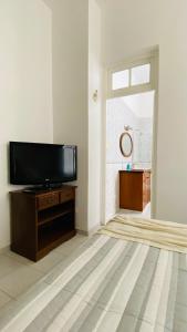 a living room with a flat screen tv on a wooden cabinet at V.60 in Nueve de Julio