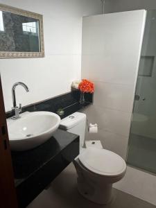 a bathroom with a white toilet and a sink at Pousada La Belle de Jour in Chapada dos Guimarães