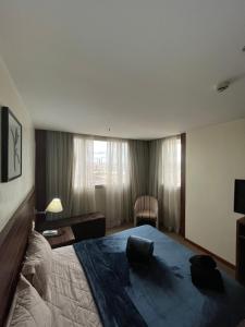 a bedroom with a large bed and a chair at Flat em Taguatinga in Taguatinga