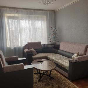 a living room with a couch and a coffee table at Уютная квартира в центре города. in Aktau