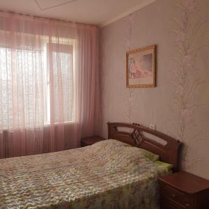 um quarto com uma cama e uma janela em Уютная квартира в центре города. em Aktau
