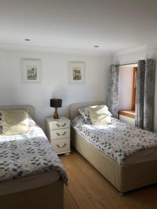 a bedroom with two beds and a mirror at Old Tynribbie House - Comfortable Detached House in Appin