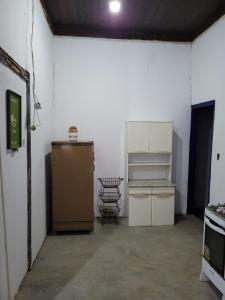 an empty garage with a kitchen with a refrigerator at Sítio das Valquírias in Taquaraçu