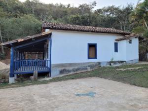 a small white house with a blue door at Sítio das Valquírias in Taquaraçu