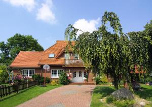 ein Backsteinhaus mit rotem Dach in der Unterkunft Pension Burggaststätte Heyken in Neuharlingersiel