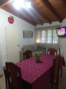 mesa de comedor con mantel púrpura y sofá en departamento 4 personas en San Rafael