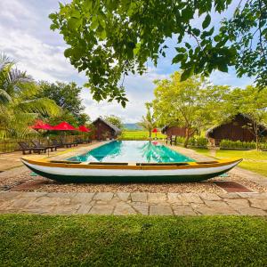 a boat sitting next to a swimming pool at Gaga Bees Yala in Tissamaharama