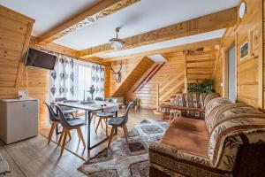 a living room with a couch and a table and chairs at Apartamenty u Bacy in Jurgów