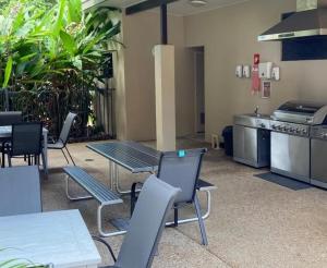 a cafeteria with a table and chairs and a kitchen at 3 bedroom 2 bath apartment in Cairns Queensland in Cairns