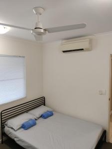 een slaapkamer met een bed met blauwe kussens en een plafond bij 3 bedroom 2 bath apartment in Cairns Queensland in Cairns
