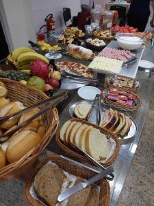 a table filled with lots of different types of bread at Londres Royal Hotel - Cama de alvenaria in Londrina