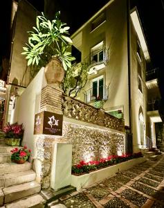 un edificio con flores a un lado. en Villa D'Orville luxury suites Taormina en Taormina