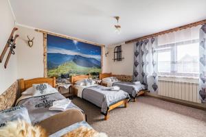 a bedroom with three beds and a large window at Apartamenty u Bacy in Jurgów