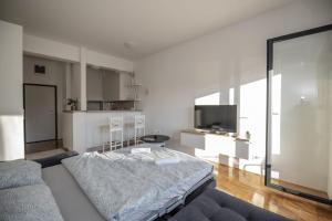 a living room with a bed and a couch at APARTMAN DERETIC in Trebinje