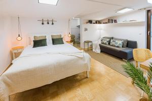 a bedroom with a large bed and a couch at Apartments Šolar in Bled