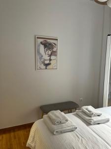 1 dormitorio con 1 cama con 2 toallas en Alex’s home next to Laiko, en Atenas