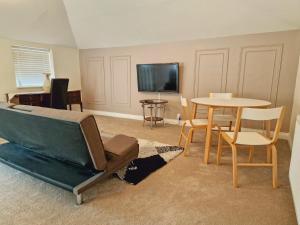 a living room with a couch and a table at Wentworth House - Free Parking in Bath