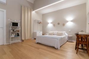 Un dormitorio blanco con una cama y una mesa. en Room24 L, en Bari