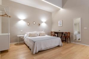 Un dormitorio blanco con una cama y una mesa. en Room24 L, en Bari