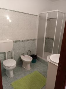 ein Badezimmer mit einem weißen WC und einem Waschbecken in der Unterkunft familiahorta in Coimbra