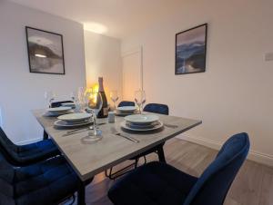 mesa de comedor con sillas y copas de vino en 3 Bed 2 Lounge House up to 40pc off Monthly in Addlestone by Angel and Ken Serviced Accommodation Great Value for Long-term Stay en Addlestone