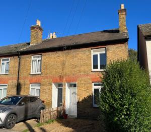 a brick house with a car parked in front of it at 3 Bed 2 Lounge House up to 40pc off Monthly in Addlestone by Angel and Ken Serviced Accommodation Great Value for Long-term Stay in Addlestone