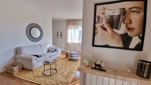 a living room with a woman holding a camera on the wall at Suite Dalmine in Dalmine