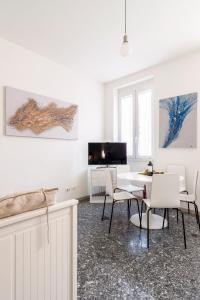 una sala de estar blanca con mesa y sillas en Italian Experience-Suite Santa Maria Gualtieri, en Pavia
