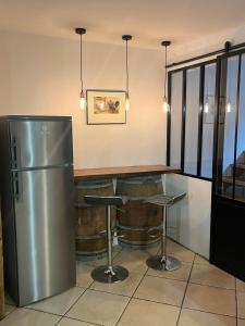 a bar with a stainless steel refrigerator and a table at La Grange Auguste avec Sauna Jacuzzi in Vénosc