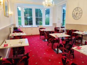 uma sala de jantar com mesas e cadeiras e um relógio em Wentworth House - Free Parking em Bath