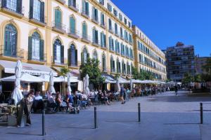 een groep mensen die buiten een gebouw zitten bij Casa La Victoria in Málaga