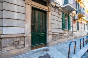 un edificio con puertas verdes en una calle en Room24 L, en Bari