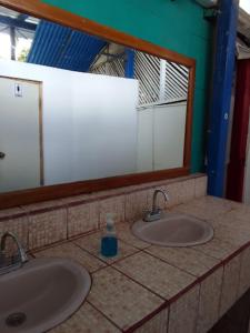 a bathroom with two sinks and a mirror at Estrella Beachfront Hotel in San Juan del Sur