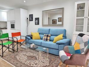 sala de estar con sofá azul y sillas en Aroma de azahar, en San Basilio en Córdoba