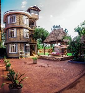 un gran edificio de ladrillo con un gran patio delante de él en Kilimanjaro Scenic Lodge, en Moshi