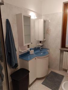 ein Badezimmer mit einem blauen Waschbecken und einem Spiegel in der Unterkunft Casa Lory in Colico