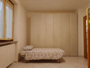 a bedroom with a bed and a cabinet at Casa Lory in Colico