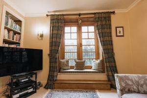 a living room with a window with a couch at STATION COTTAGE - Unique Accommodation with River Flowing through Garden in Bolton Abbey