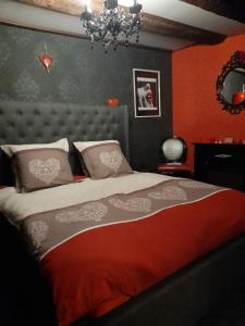 a bedroom with a bed with red walls and a chandelier at LOVE ROOM Le rouge et noir in Barr