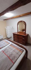 ein Schlafzimmer mit einer Kommode und einem Bett mit einem Spiegel in der Unterkunft Ferienwohnung in Timmenrode am Harz in Timmenrode