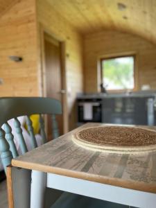 una mesa y sillas en una habitación con cocina en Park Hill Pod, en Stratford-upon-Avon