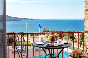 - une table sur un balcon avec vue sur l'océan dans l'établissement Le Catalan, à Banyuls-sur-Mer