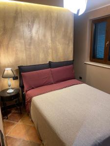 een slaapkamer met een bed met rode kussens en een raam bij Colle De Siena Rooms in Cassino