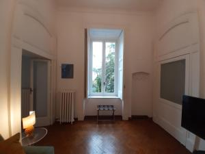 a living room with a large window and a table at Casa Antica Pizzofalcone in Naples