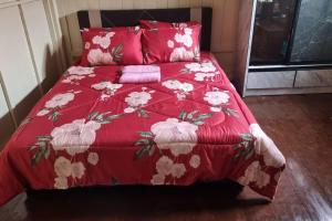 a red bed with a red comforter and pillows at Teratak An Nur: A village on top of the hill in Kuala Pilah