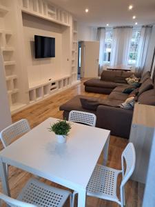 uma sala de estar com uma mesa branca e cadeiras em RAJ Living - 5 Room House with Terrace - 35 Min to Messe DUS em Mönchengladbach