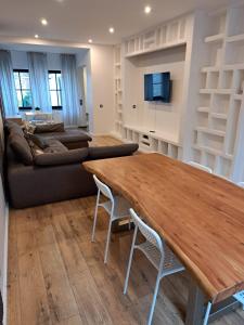 a living room with a wooden table and a couch at Tolstov House - 5 Room House with Terrace - 35 Min to Messe DUS in Mönchengladbach
