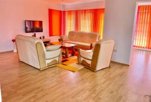 a living room with chairs and a table and a dining room at Villa TeslaS in Velika Kladuša