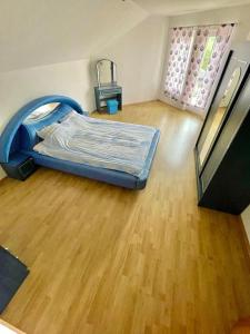 a room with a bed and a wooden floor at Villa TeslaS in Velika Kladuša