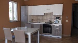a kitchen with white cabinets and a table and chairs at Villa Galati Resort in Mascali